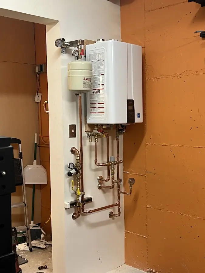 Plumbing technician inspecting water heater connections in Shakopee
